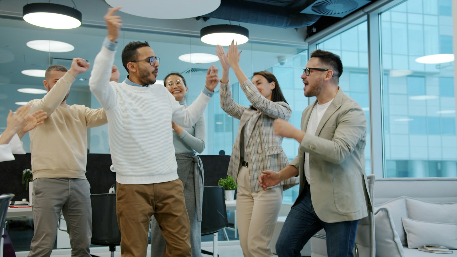 Mitarbeiterbeteiligung: Team feiert gemeinsam einen Erfolg im Büro