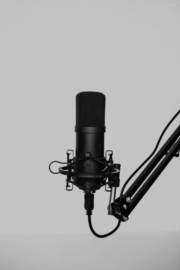 Podcast-Werbung: schwarzes Kondensatormikrofon mit Spinne an einem Gelenkarm im Studio