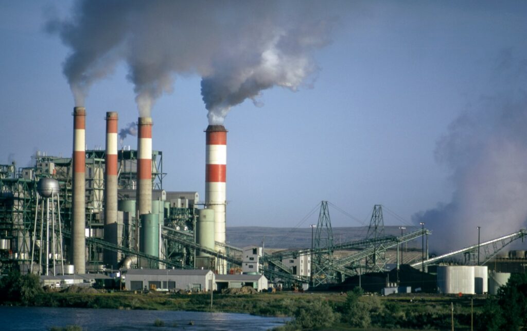 CO2-Preis 2027: Kraftwerk mit rauchenden Schornsteinen vor blauem Himmel