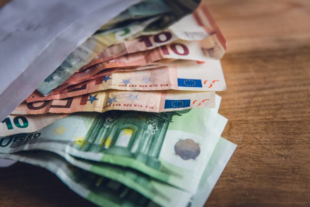 Digitaler Euro als Ergänzung zum Bargeld: verschiedene Euro-Banknoten auf einer Holzoberfläche