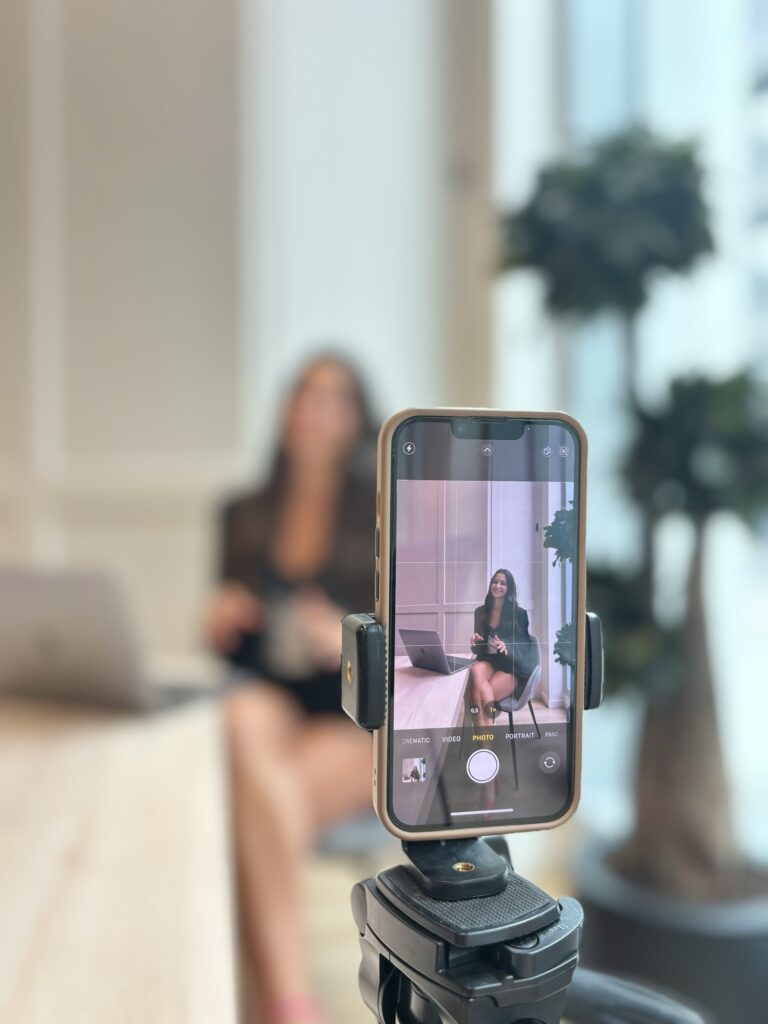 Employer Branding auf LinkedIn: Mitarbeiterin nimmt im Büro ein Kurzvideo mit dem Smartphone auf