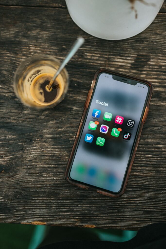 Smartphone mit Social-Media-Apps neben einer Tasse Kaffee