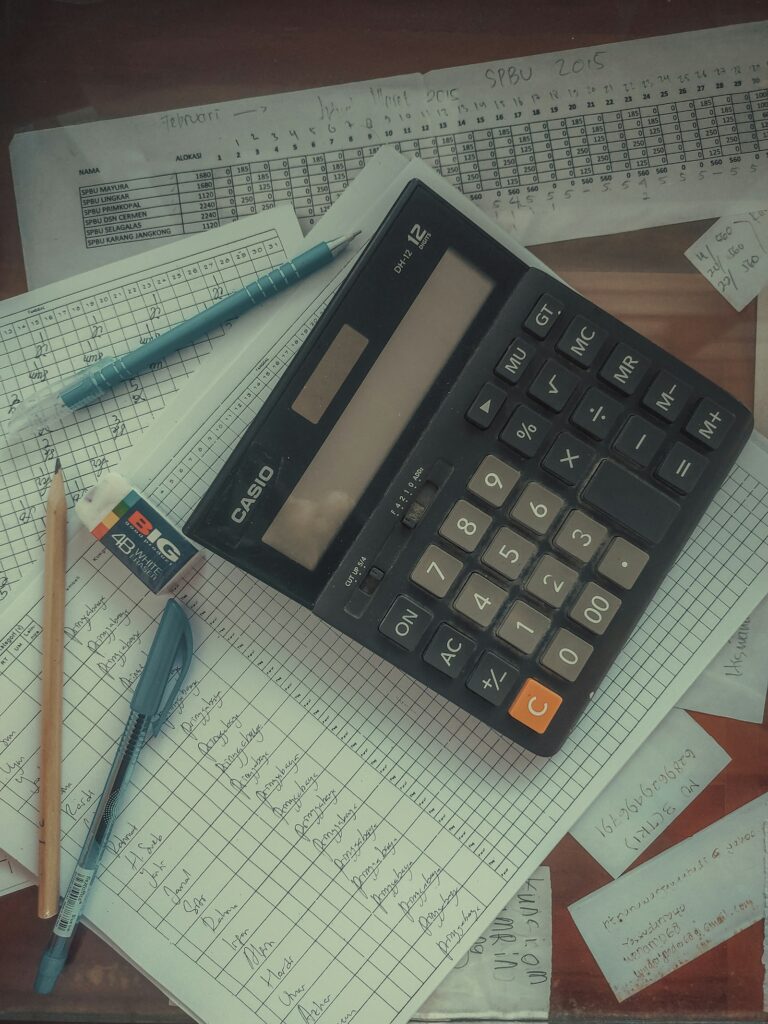 Entgelttransparenzgesetz und Gehaltsanalyse: Taschenrechner liegt auf einem Stapel Papiere im Büro