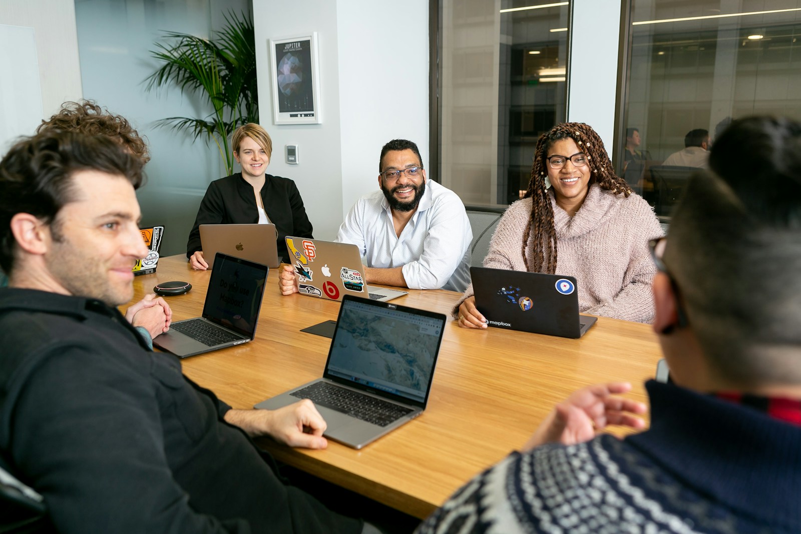 Entgelttransparenzgesetz im Unternehmen: Team mit Laptops bespricht in einem Meeting die Vergütungsstruktur