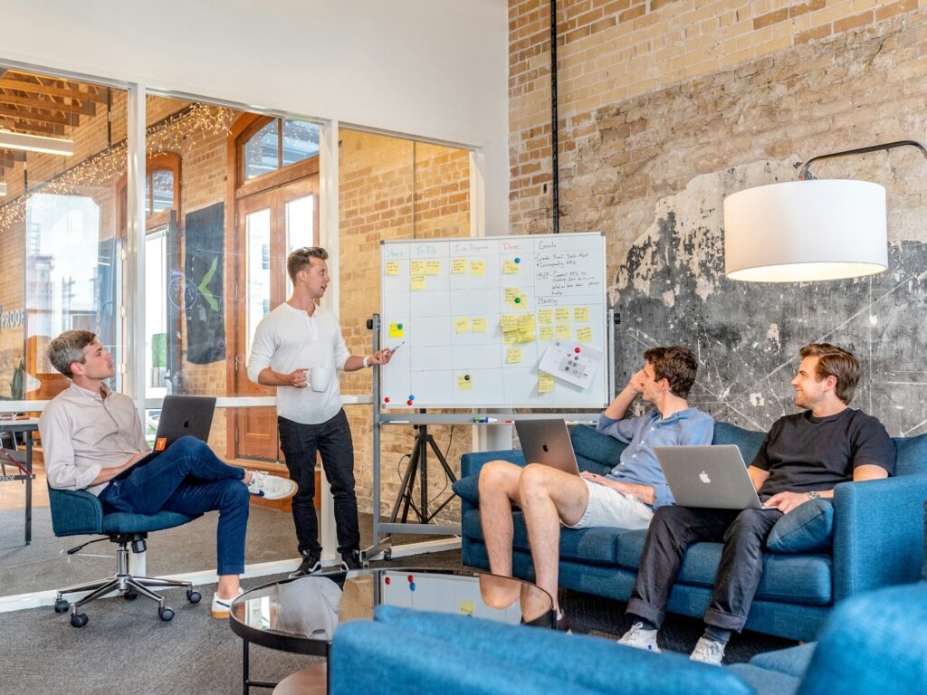 Startup-Finanzierung: Gründerteam am Laptop vor einem Whiteboard