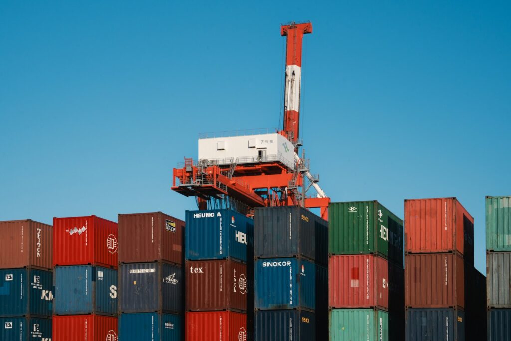 Lieferkettengesetz 2026: Containerkran über gestapelten Frachtcontainern im Hafen
