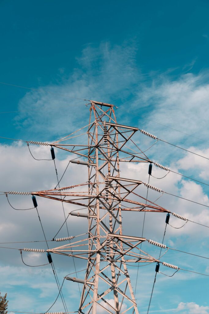 Netzentgelte und Stromnetz: Hochspannungsmast vor blauem Himmel als Symbol für steigende Netzkosten der Industrie