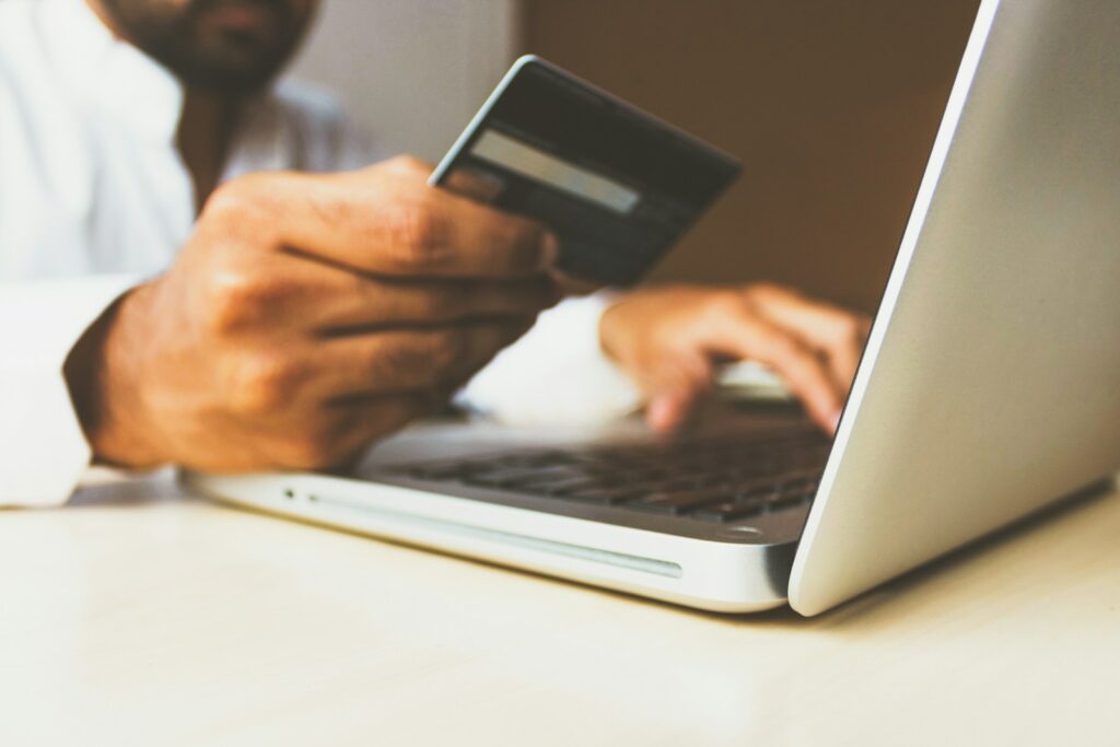 Retail Media: Person bezahlt online mit Kreditkarte am Laptop