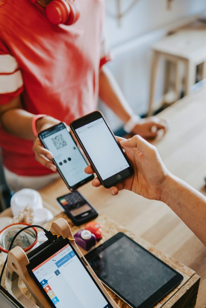 Wero: Zwei Personen halten in einem Café ihre Smartphones nebeneinander