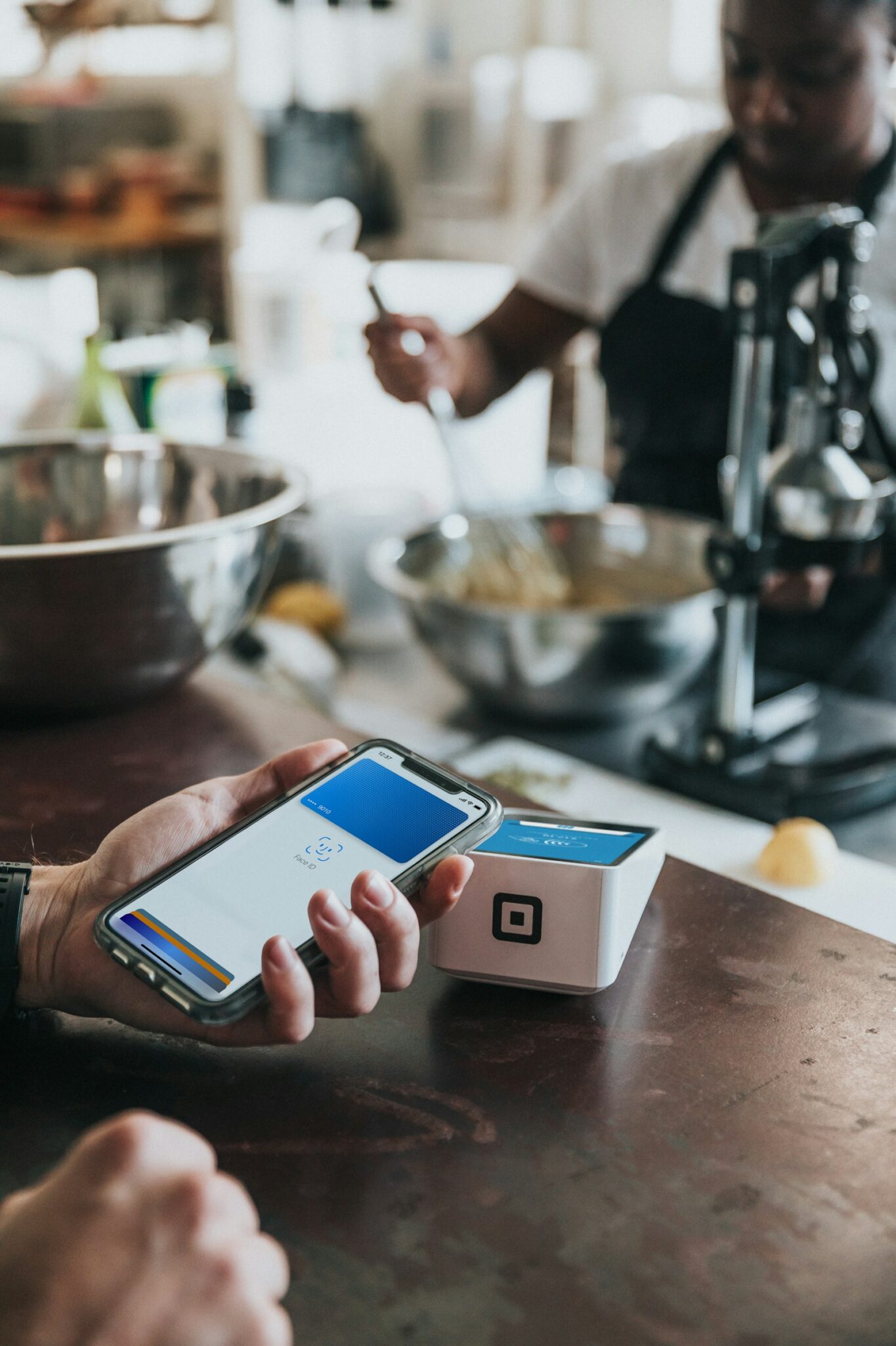 Wero: Person hält ihr Smartphone zum Bezahlen an ein kontaktloses Kartenterminal