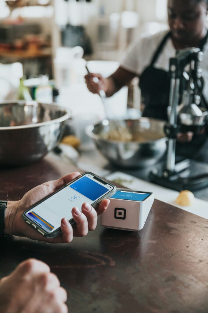 Wero: Person hält ihr Smartphone zum Bezahlen an ein kontaktloses Kartenterminal